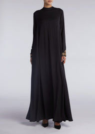 This simple yet elegant abaya features embroidery on the back and cuffs. Inspired by Islamic Art of Calligraphy. 'Celi' Is the name of a pen used for large forms of calligraphy. Black.