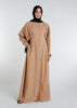 This Maxi Shirt Dress Sand features cuffed sleeves and pockets, giving the appearance of a tucked-in shirt and skirt when it is actually a one-piece outfit. Pleats at the waist create a cinch, while the top half remains loose for a comfortable fit. The dress is cut in an A-line style. Neutral beige tone.