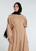 This Maxi Shirt Dress Sand features cuffed sleeves and pockets, giving the appearance of a tucked-in shirt and skirt when it is actually a one-piece outfit. Pleats at the waist create a cinch, while the top half remains loose for a comfortable fit. The dress is cut in an A-line style. Neutral beige tone.